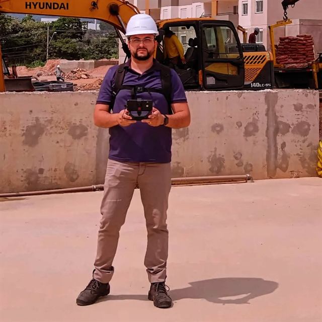 Piloto da MoviDrone operando o drone em canteiro de obras com capacete de segurança
